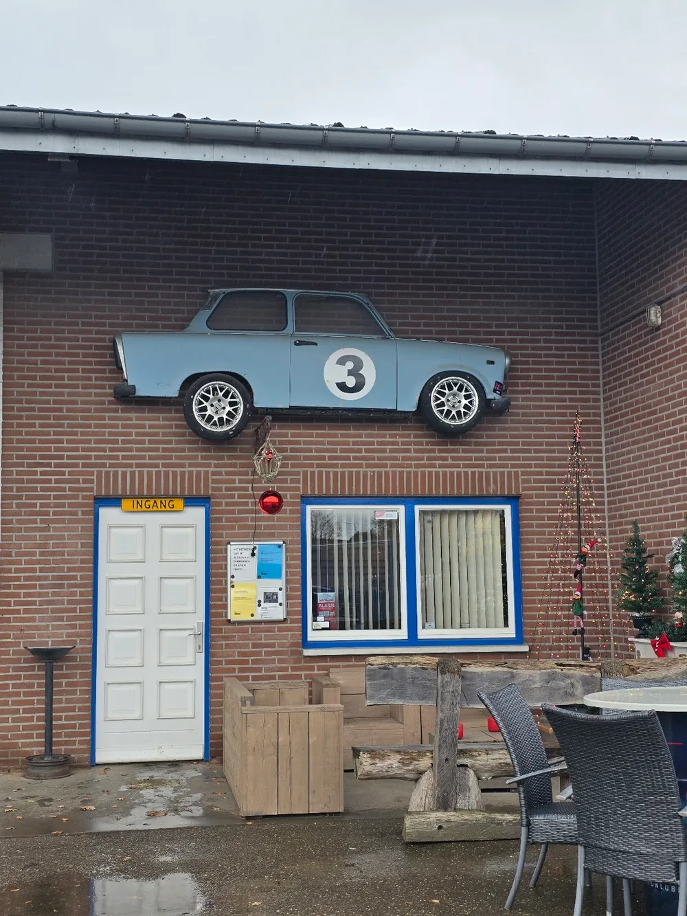De gevel van Auto Weber met een klassieke rally-Trabant met startnummer 3 aan de muur