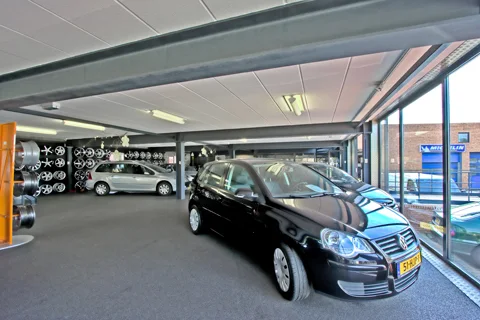 Overdekte showroom van Auto Weber met occasions en een wand vol lichtmetalen velgen