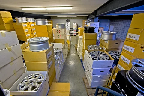 Magazijn vol lichtmetalen velgen in dozen bij Auto Weber